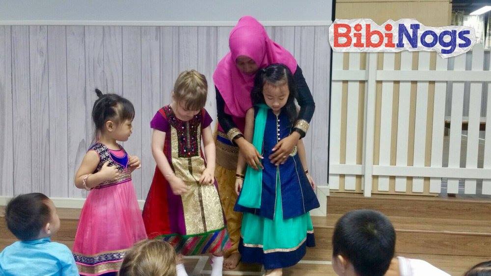 The teacher showcases and describes different types of traditional Indian costumes